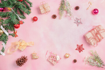 Christmas composition with decorations and gift box with bows on pink pastel background. winter, new year concept. Flat lay, top view, copy space.