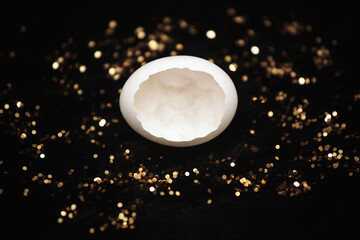 Eggshell on black fur with golden glitter close-up