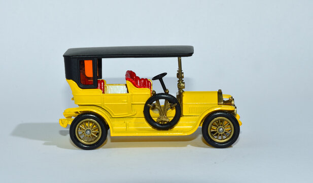 Toy diecast model of a Yellow  1907 Peugeot  a Matchbox yesteryear  product by Lesney with white background