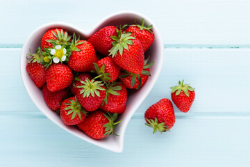 Strawberry heart. Fresh strawberries in plate on white wooden table. Top view, copy space.