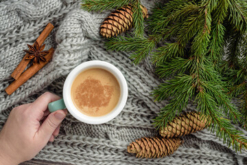 Winter composition with fir branches, a blanket and a mug with cocoa.