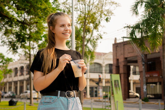 Young beautiful cute Brazilian female drinking Somo, a Bolivian drink