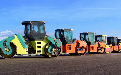 road construction and asphalt compaction with yellow road rollers. Parking lot of road rollers in a row