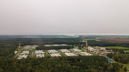 Fototapeta premium Overall plan of aerial photo of a sugar factory during the beet campaign, photo taken with a drone. Industrial concept. Ecological problem.