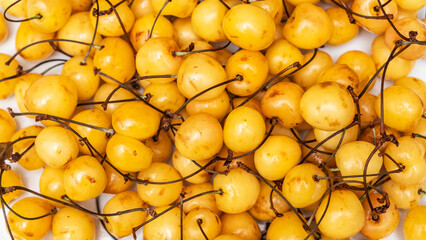 A lot of yellow cherries on sale at farms market. Defocused background. Harvest concept. Sweet...