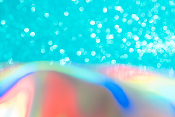 Abstract mixed holographic blue ai aqua blurred glitter shiny background. Liquid neon rainbow foil unicorn style. Bright sparkling bokeh style. Festive Christmas holiday iridescent futuristic texture.