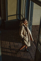 Full-length outdoor fashion portrait of elegant woman wearing trendy autumn, winter outfit: faux...