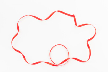 Top view of Red ribbon isolated shiny rolled on white background. Flat lay view.