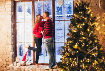 lovers cuddle near the winter window