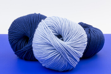 woolen merinos blue threads on blue and white background. natural wool. knitting. background