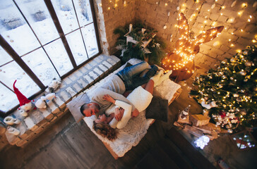  lovers cuddling on the bed near the christmas tree