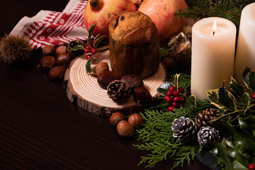 Christmas decoration with a baked panettone and seasonal fruits.