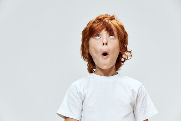 surprised boy with open mouth looking up white t-shirt cropped