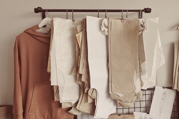 Many paper brown patterns for sewing clothes for babies and newborns of different sizes hanging on...