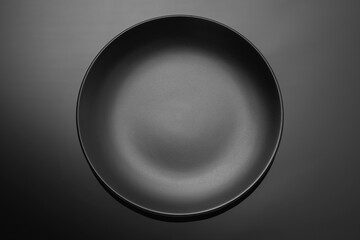 Empty black plate on a dark gradient background