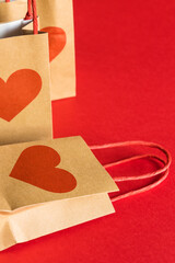 Valentine's Day concept. Shopping paper bags with hearts print on red background. 