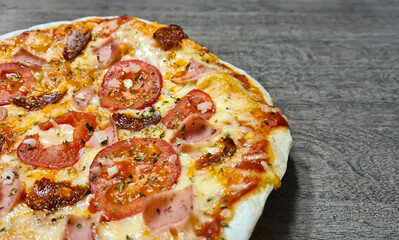 Homemade pizza with mozarrella, tomato, ham, chorizo ​​and onion