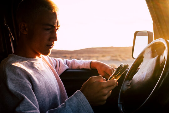 Teenager (16-17) in car using smartphone