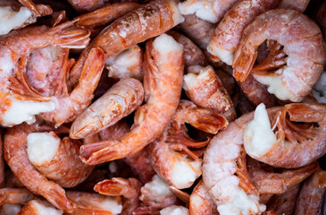 Close-up of a pile of large frozen red shrimps. Natural bright seafood background