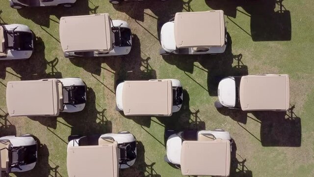 Close Up of Golf Buggy Roofs on Green Golf Course, Aerial Shot