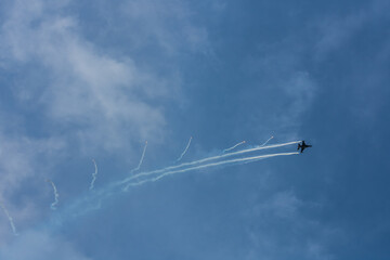 fighter plane flies sideways with defensive measures at a air show