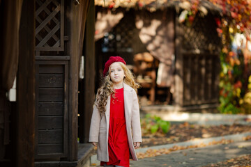 Fototapeta na wymiar Cute girl in red beret on a walk in the fall