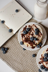 Delicious pancakes with blueberries, chocolate and a bottle of milk. Healthy eating. Morning tasty homemade breakfast, stack of fluffy and delicious sugar free pancakes. White background.
