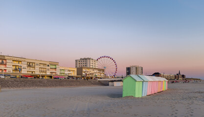 Pastel colored beach cabins and giant wheel along the Opal Coast in the North of France.