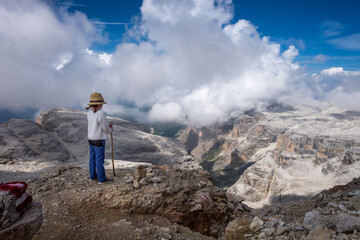Unrecognisable young child overlooking the landscape on top of the Sella Group massif in the Italian Dolomites
