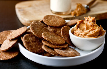 Close up of sesame crackers with peanut butter served on plate