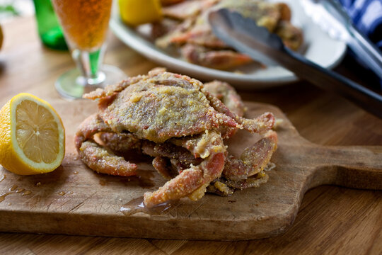 Close up of fried soft shell crabs with cornmeal coating served on cutting board