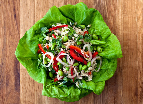 Overhead view of Thai style sprouted rice and herb salad served on leaf