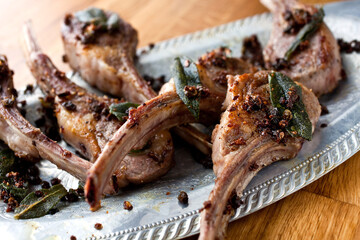Close up of fried lamb chops with anchovies and capers served on plate