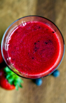Overhead view of berry and rose geranium smoothie in glass
