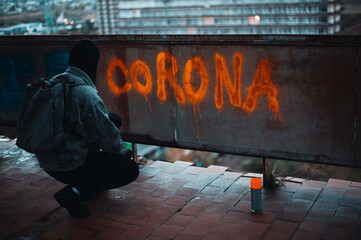 Naklejka premium Protester on the roof writes corona with spray paint 