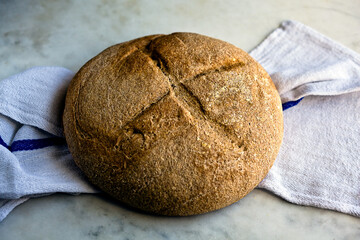 Close up of country bread with cornmeal on napkin