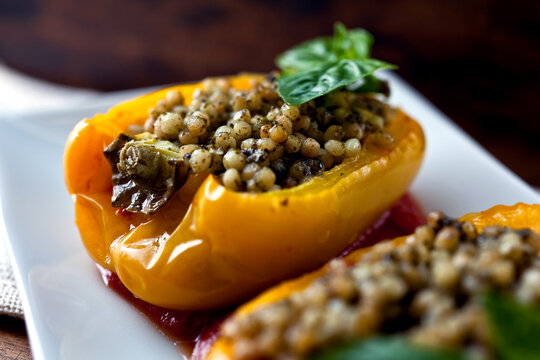 Close up of stuffed yellow peppers with Israeli couscous and pesto