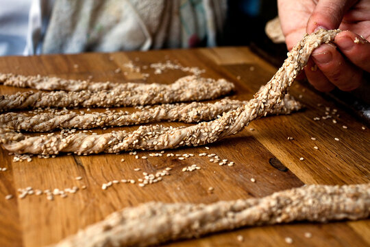 Close up of man holding whole wheat sesame breadsticks