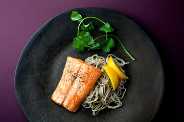 Overhead view of roasted arctic char with pine nut soba and meyer lemon served on plate