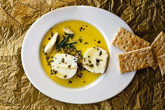 Overhead view of marinated goat cheese served with crackers