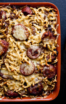 Overhead view of spaetzle with smoked kielbasa and caramelized onions served in tray
