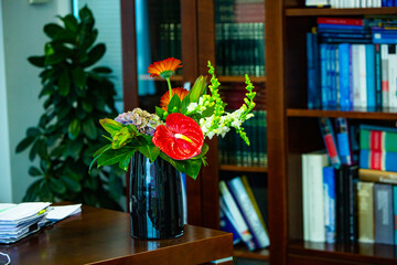 Working table with vase of flowers in modern office. Bouquet of flowers on a table in a modern room.