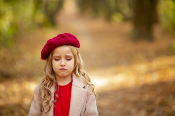 Cute girl in red beret on a walk in the fall