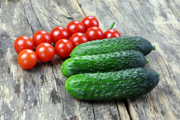 Cherry tomatoes and cucumbers on a wooden background. Vegetables on a old wooden table. Healthy food. Vegan food