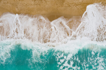 Blue sea wave on sandy beach. Sea shore top view