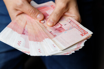 Man holds yuan. Currency of the China - One red hundred renminbi or yuan notes