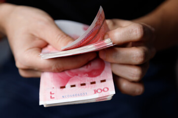 Man counts yuan. Currency of the China - One red hundred renminbi or yuan notes - obrazy, fototapety, plakaty