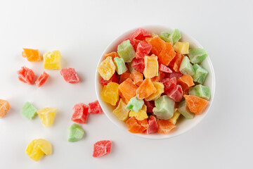 Candied fruits in a white bowl on a white background