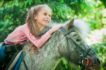 Girl rides a close-up pony