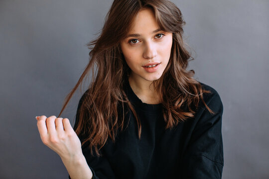 Magnificent alluring brunette against gray wall